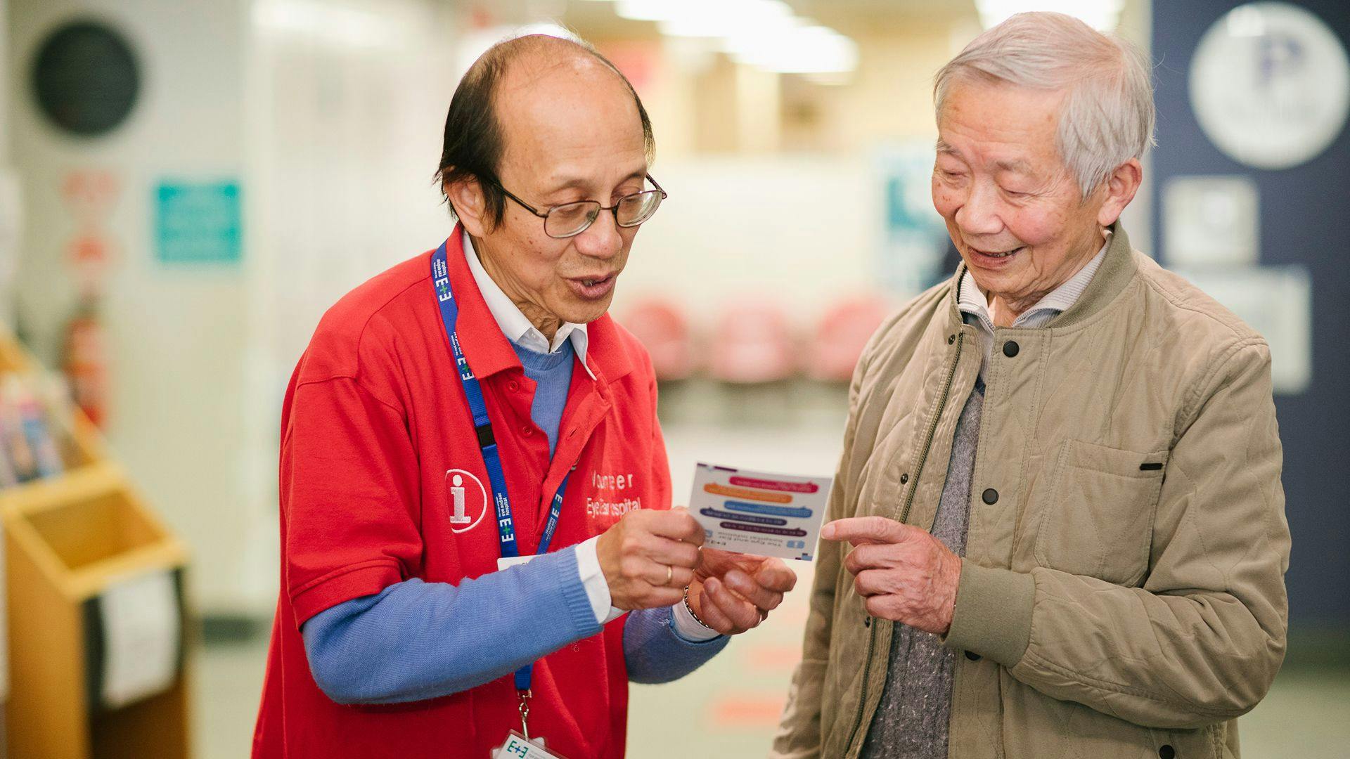 A volunteer at the hospital giving information to a visitor